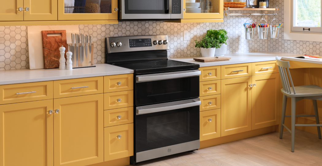 electric stove in a kitchen with yellow cabinets and white countertop